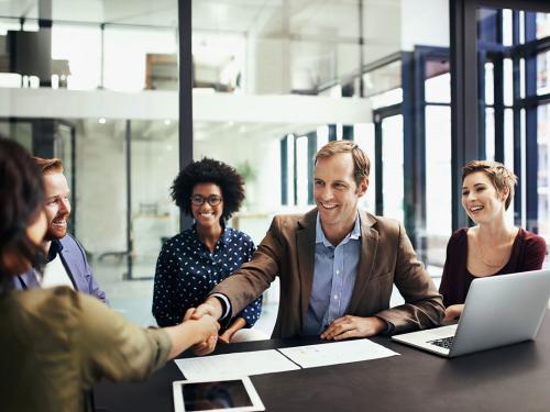 Developing business interests by striking up a deal Shot of colleagues shaking hands during a meeting at work