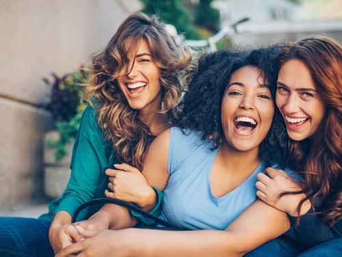 Happy girlfriends Three young women laughing outdoors